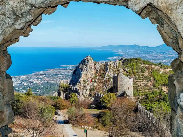 View through a stone arch at St Hilarion Castle towards the coast