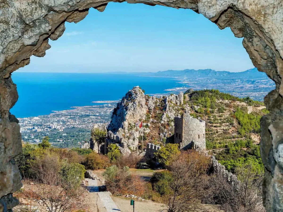 View through a stone arch at St Hilarion Castle towards the coast