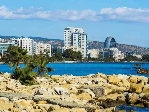 Limassol seafront towers seen across a rocky shore