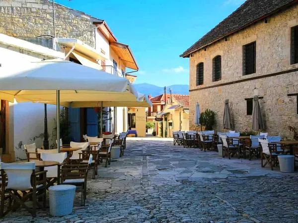 Café tables on a stone-paved street in Omodos