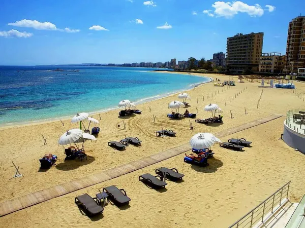 Sunbeds on the sand beside Varosha’s empty hotels