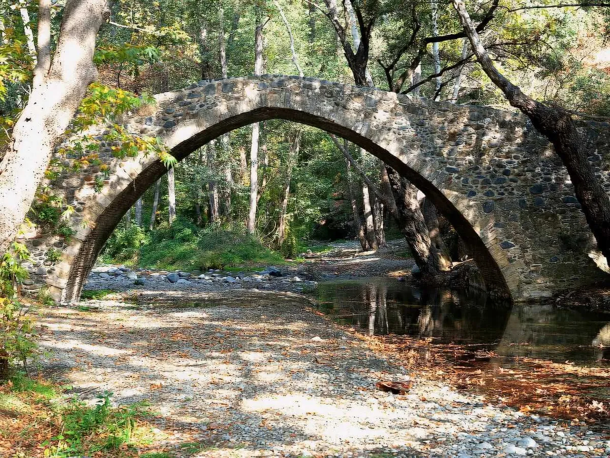 Arched Venetian stone bridge over a stream in the Troodos forest