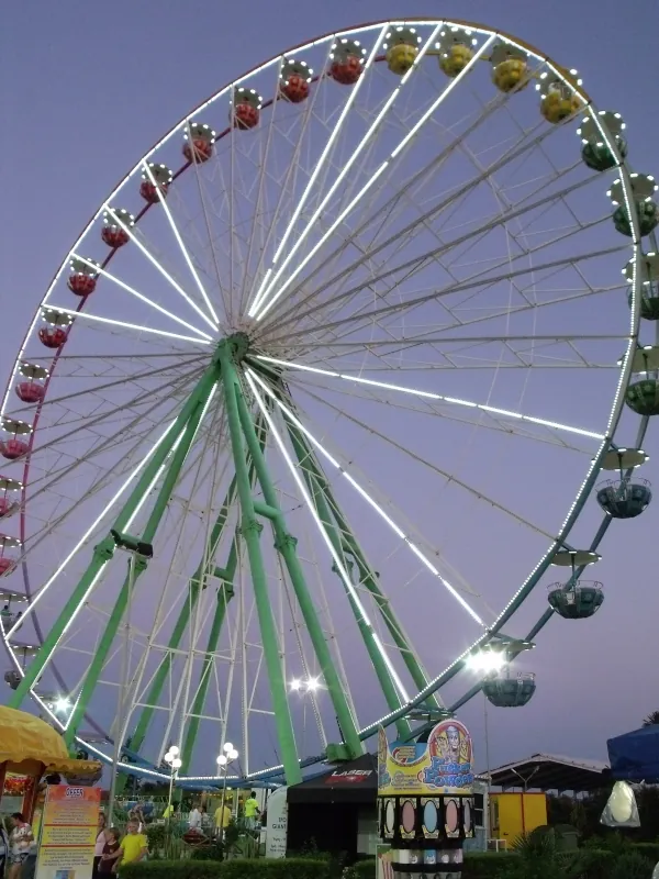 Giant Ferris wheel lit up at dusk at the Ayia Napa fun park