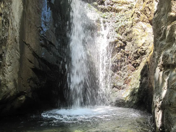 Millomeris waterfall falling into a pool in a rocky gorge near Platres