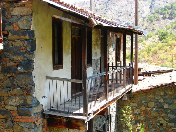 Stone house with a wooden balcony in Askas