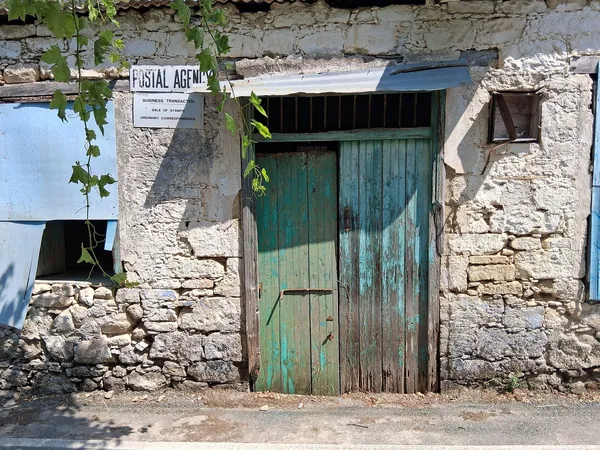 Old stone house with a green door in Miliou